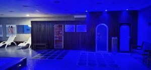 Cette chambre est dotée de lumières bleues, d'une porte et de chaises. dans l'établissement Hotel Marítimo Ris con garaje, à Noja