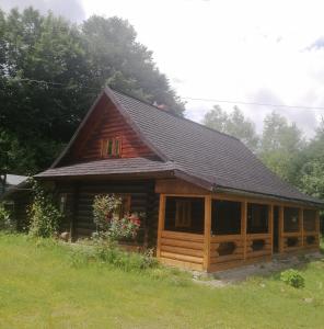 une grande cabane en bois dans un champ arboré dans l'établissement Stara Khata Карпати, à Sheshory