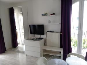 a living room with a tv and a dresser with a tvicterictericter at Ana Rooms in Krk