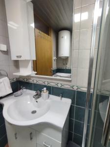 a bathroom with a sink and a mirror at Merkur Lux in Budva +4 photos