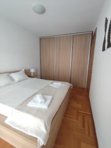 a bedroom with a bed with two towels on it at Merkur Lux in Budva