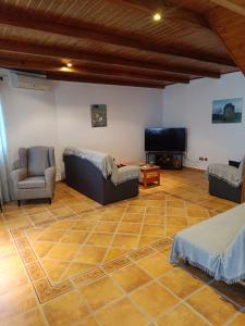 ein Wohnzimmer mit Sofa und Fernseher in der Unterkunft Aires Del Ambroz in Casas del Monte