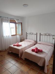ein Schlafzimmer mit 2 Betten mit rosa Bogen in der Unterkunft Aires Del Ambroz in Casas del Monte + 39 Fotos