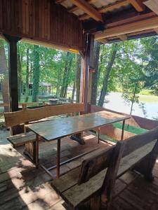 einem Picknicktisch und einer Bank in einer Hütte in der Unterkunft LAKE FISHING Resort in Lukinić Senovec