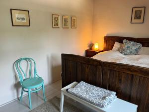 a bedroom with a bed and a blue chair at Kővirág Panzió in Köveskál
