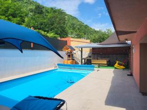 Ein Swimmingpool mit blauem Wasser und Bergen im Hintergrund in der Unterkunft Villa Harmony in Bihać