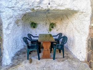 a table and chairs in a stone wall at Casa Cueva Barranco Hondo in Gáldar