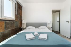a bedroom with a large bed with towels on it at BLife Charlya private apartment in Faro