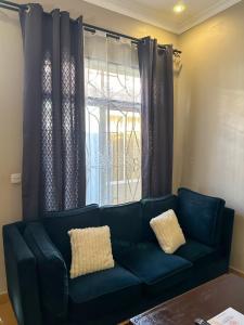 a blue couch in a living room with a window at Actionpack Travels in Dar es Salaam