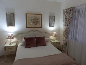 a bedroom with a white bed with two lamps on tables at Mountain View Holiday Home in Franskraal