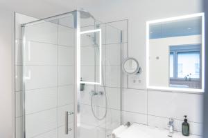 a white bathroom with a shower and a sink at Apartments Trier in Trier