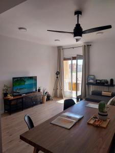 Una sala de estar con una mesa y un televisor. en Apartamento grande en Huesca, en Huesca