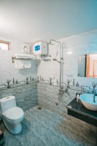a bathroom with a toilet and a sink at Tam Coc Ninh Binh Bungalow in Ninh Binh