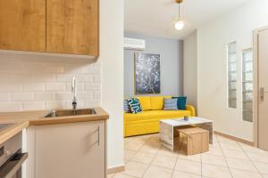 a kitchen and a living room with a yellow couch at Koukos Loft Apartments in Tsilivi