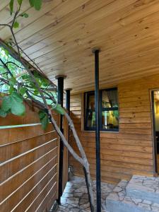 a wooden house with two poles in front of it at Big stone in Dilijan