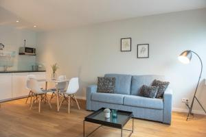a living room with a blue couch and a table at Apartments Trier in Trier