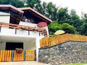 a house with a fence and two umbrellas on top at Casa San Bartolomè in Ornavasso