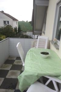 エッシュボルンにあるFerienwohnung Karinのパティオ(緑のテーブルクロス付きのテーブルと椅子付)