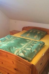 エッシュボルンにあるFerienwohnung Karinのベッド(上に緑色の掛け布団付)