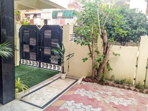 a courtyard with a tree and a fence at Serene Stays at Varanasi - 2BHK Luxury Villa in Varanasi