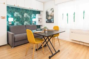 un soggiorno con tavolo, sedie e divano di Frontière de Monaco - Studio rénové - AE a Beausoleil