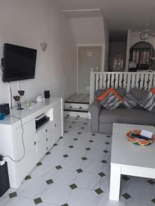 a living room with a couch and a tv at El Marques Resort Townhouse in Puerto de Santiago