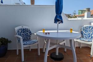 a white table and two chairs with drinks on a balcony at El Marques Resort Townhouse in Puerto de Santiago