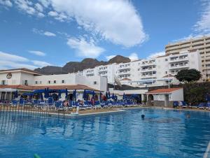a swimming pool in front of a hotel at El Marques Resort Townhouse in Puerto de Santiago