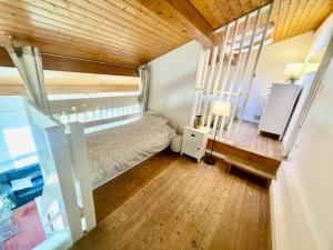 a small bedroom with a bed and a wooden ceiling at Beau loft en duplex proche plage et centre ville in Cabourg