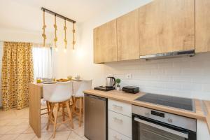 a kitchen with a counter and a table with chairs at Koukos Loft Apartments in Tsilivi