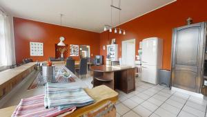 a kitchen with orange walls and a kitchen with a table at Ferienhaus alte Dorfschule Dolgen in Dolgen