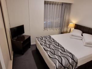 a hotel room with a bed and a television at Accommodation Sydney 38 Harbour Street Sydney in Sydney +43 photos