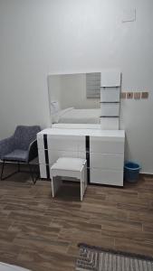 een slaapkamer met een wit bed en een stoel bij فندق السد الخليجى in Sīdī Ḩamzah