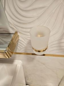 Una vela en un vaso sobre una mesa en فندق السد الخليجى en Sīdī Ḩamzah
