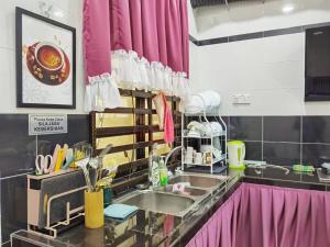 a kitchen with a sink and a pink curtain at SEMI-D Marfis Homestay in Ajil