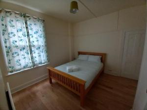 ein kleines Schlafzimmer mit einem Bett und einem Fenster in der Unterkunft Jazmin in Hendon