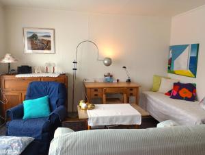 ein Wohnzimmer mit einem Sofa und einem Stuhl in der Unterkunft Kongsfjord Holiday Home in Kongsfjord