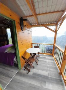 a room with a bed and a table on a balcony at Cabaña Rustica Durango in Salento