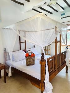 1 dormitorio con cama con dosel y cesta. en Chokoro House en Paje