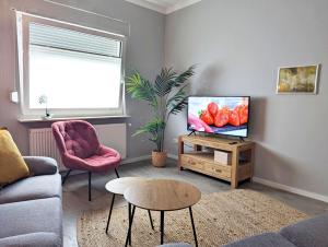 a living room with a couch and a tv at Apartmenthaus GOLDGRUBE in Koblenz