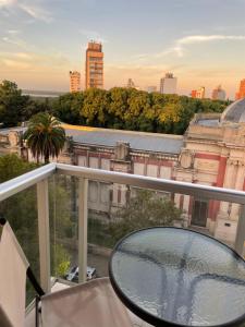 a balcony with a glass table and a view of a city at Los Lapachos in Paraná
