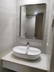 a bathroom with a white sink and a mirror at City Hub 523 in Baguio +4 photos