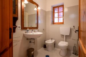 Un baño con lavabo, inodoro y espejo. en Trullo with Private Garden and Pine Forest, en Martina Franca 28 fotos más