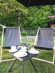 two chairs and a table with plates of food on it at Małopolskie Swojskie in Olszyny +35 photos