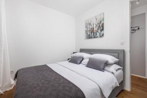 a bedroom with a bed with white sheets and pillows at Luxury apartment Mon Soleil 2 in Murter