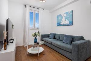 a living room with a couch and a sailboat on the wall at Luxury apartment Mon Soleil 2 in Murter