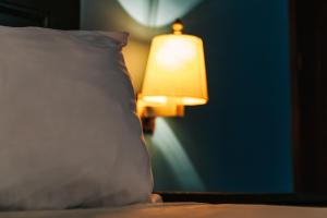 un letto con cuscino e lampada in una stanza di Hotel Brisa a Punta Cana
