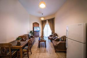 a kitchen and living room with a refrigerator and a table at Umm Al Quwain Beach Hotel in Umm Al Quwain