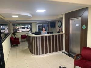 a woman sitting at a bar in an office at Hotel Tropical in Porto Velho