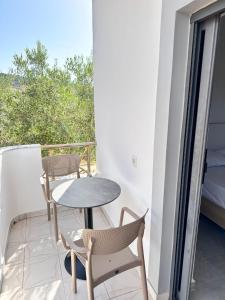 a small table and chairs on a balcony at Villa Soni Oruci in Ksamil
